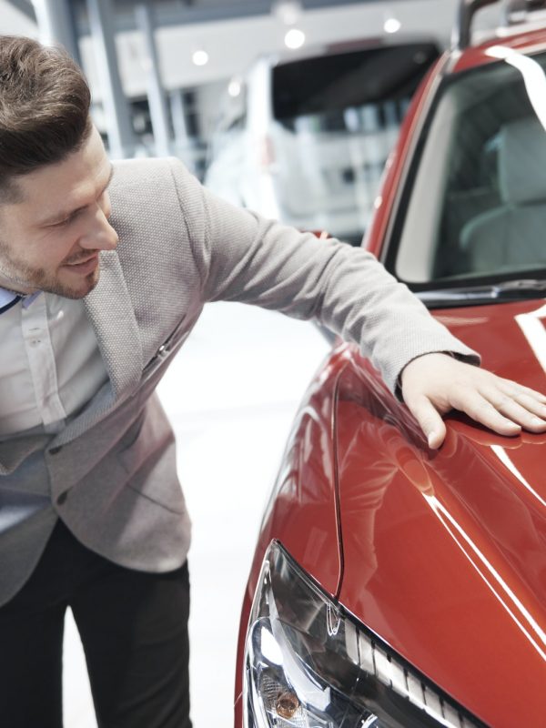 Car salesman examining vehicle before selling