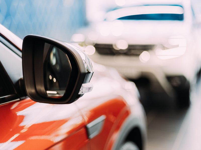 Cars Parked Indide at Dealer Shop. Close Up Of Vehicle Mirror. Dealer Showroom. Sale Trade New Cars