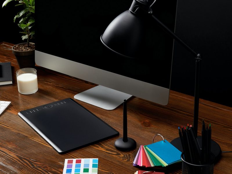 close up view of graphic designer workplace with colorful pallet, graphic tablet, blank computer