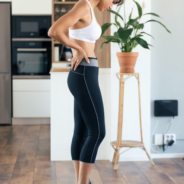 Healthy young woman looking if she has lost weight on scale weight at home.