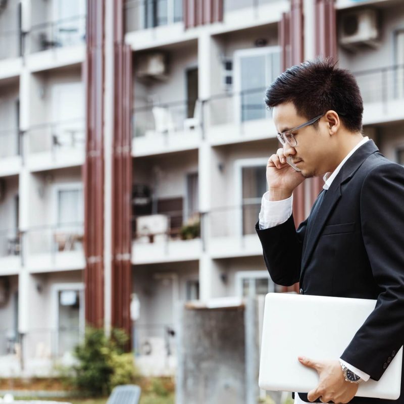 concept-business-handsome-asian-business-man-working-on-property-investment-with-laptop