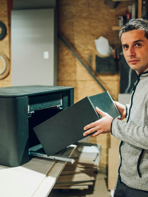 A carpenter is joining furniture in his workshop.