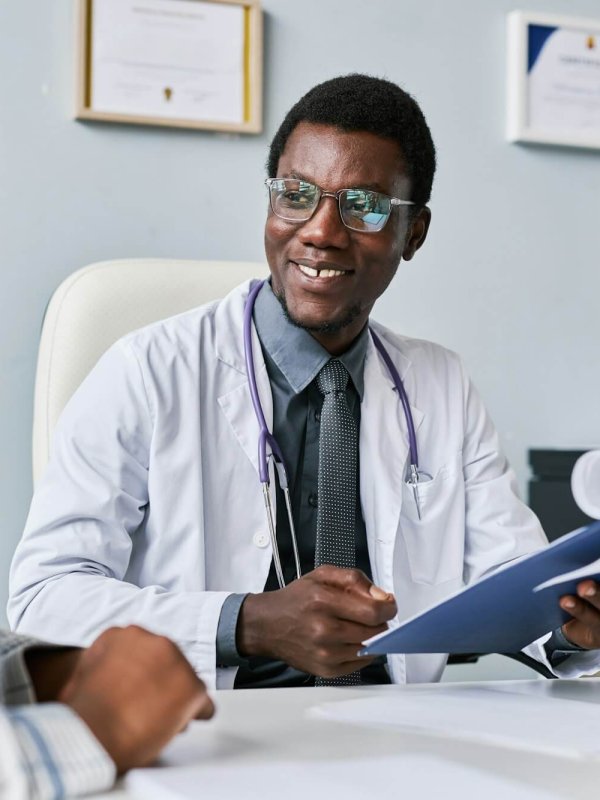 Smiling black doctor consulting female doctor in clinic