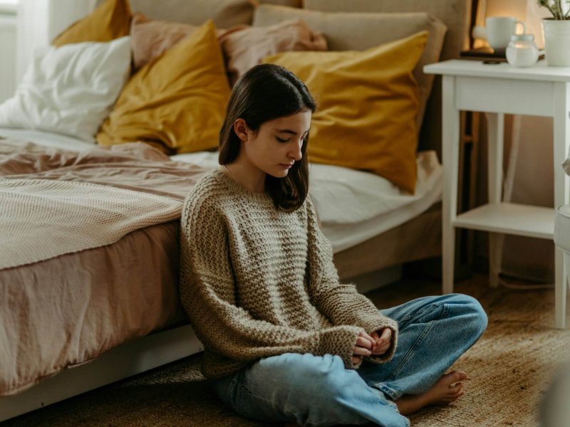 Unhappy teenage girl sitting on the floor, koncept of mental health.