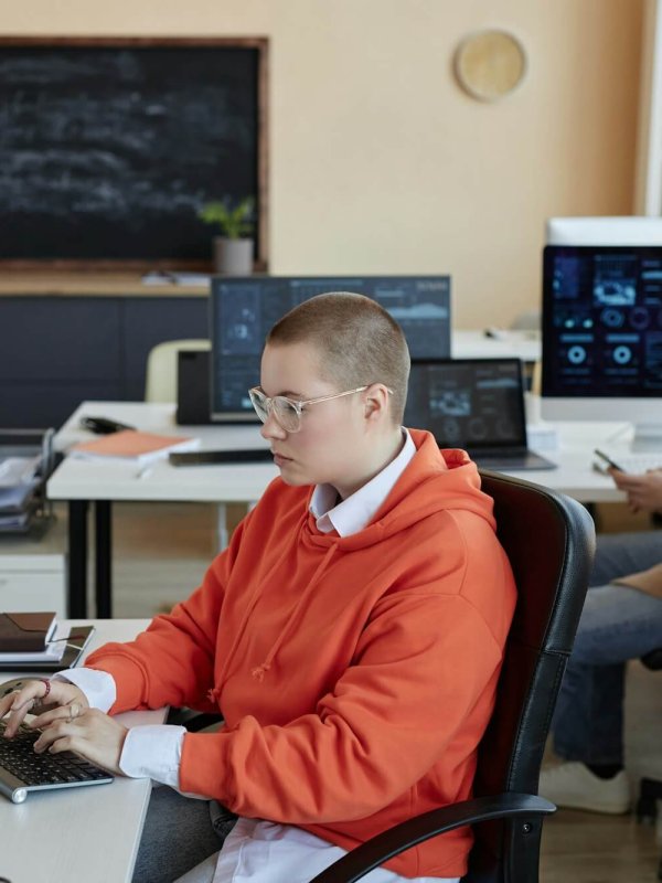 Side view of young busy female specialist in cyber security networking